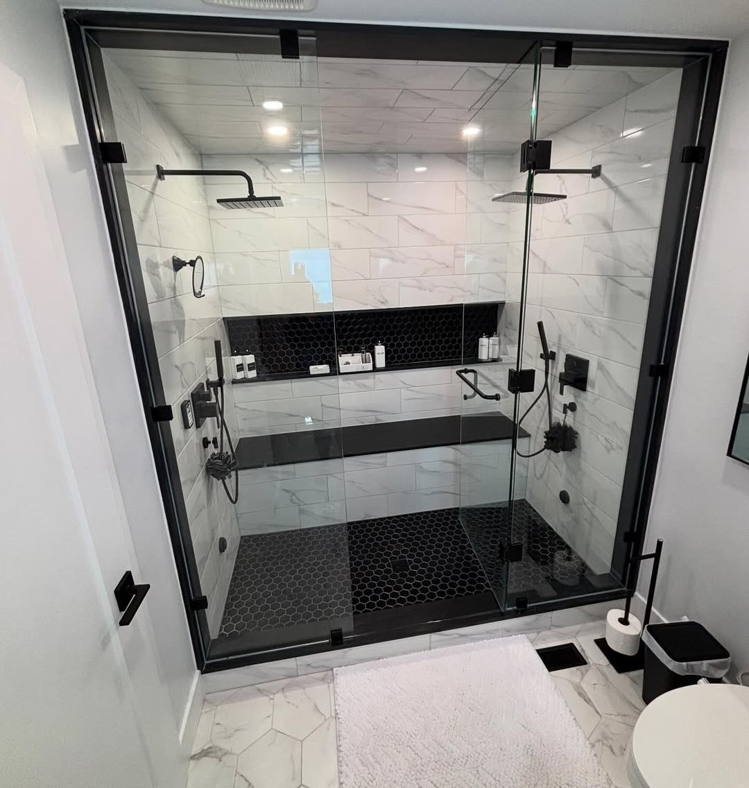 Renovated bathroom with tile, glass, and custom vanity.